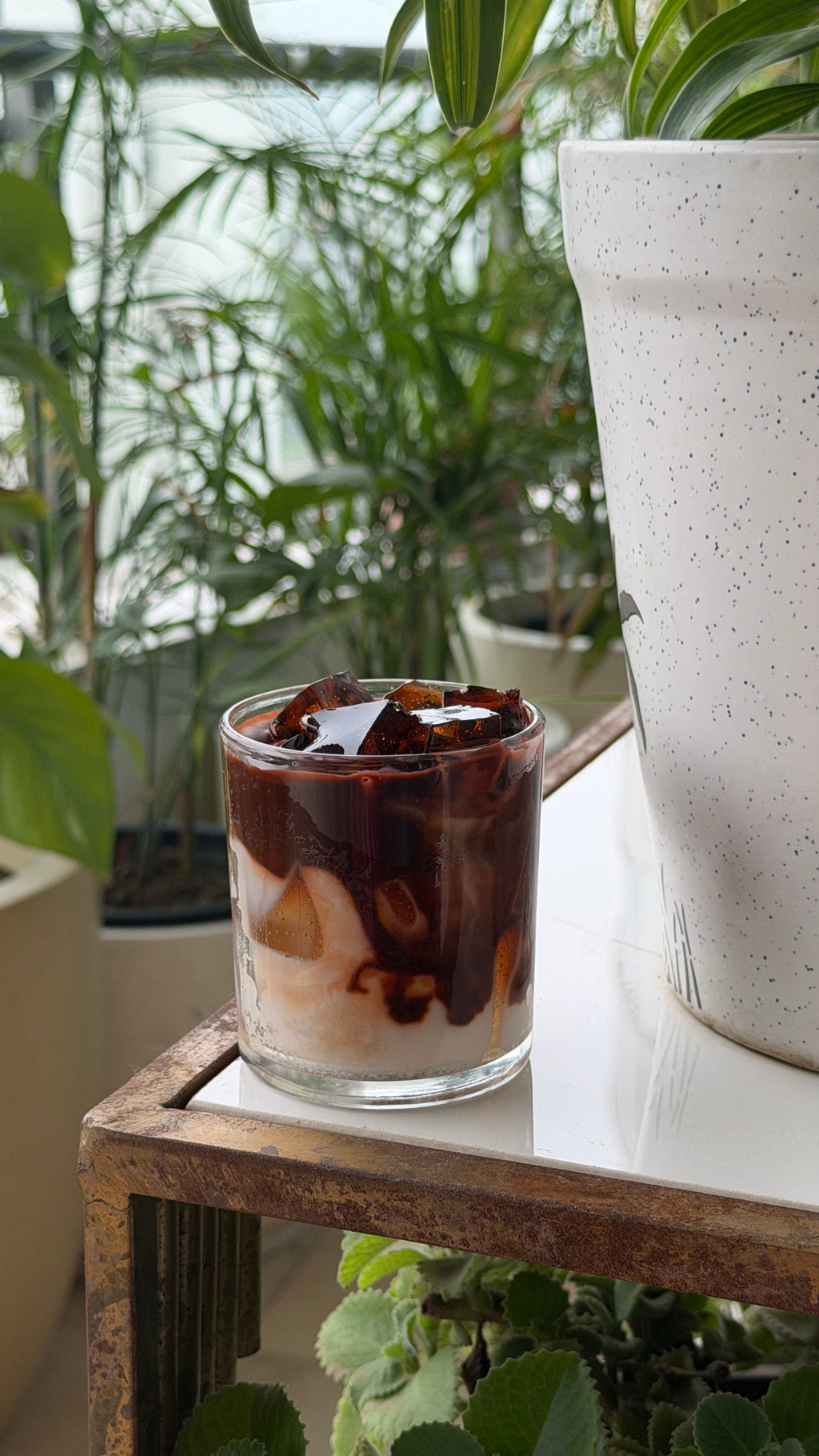 Cold coffee candle in a glass tumbler photographed in natural daylight