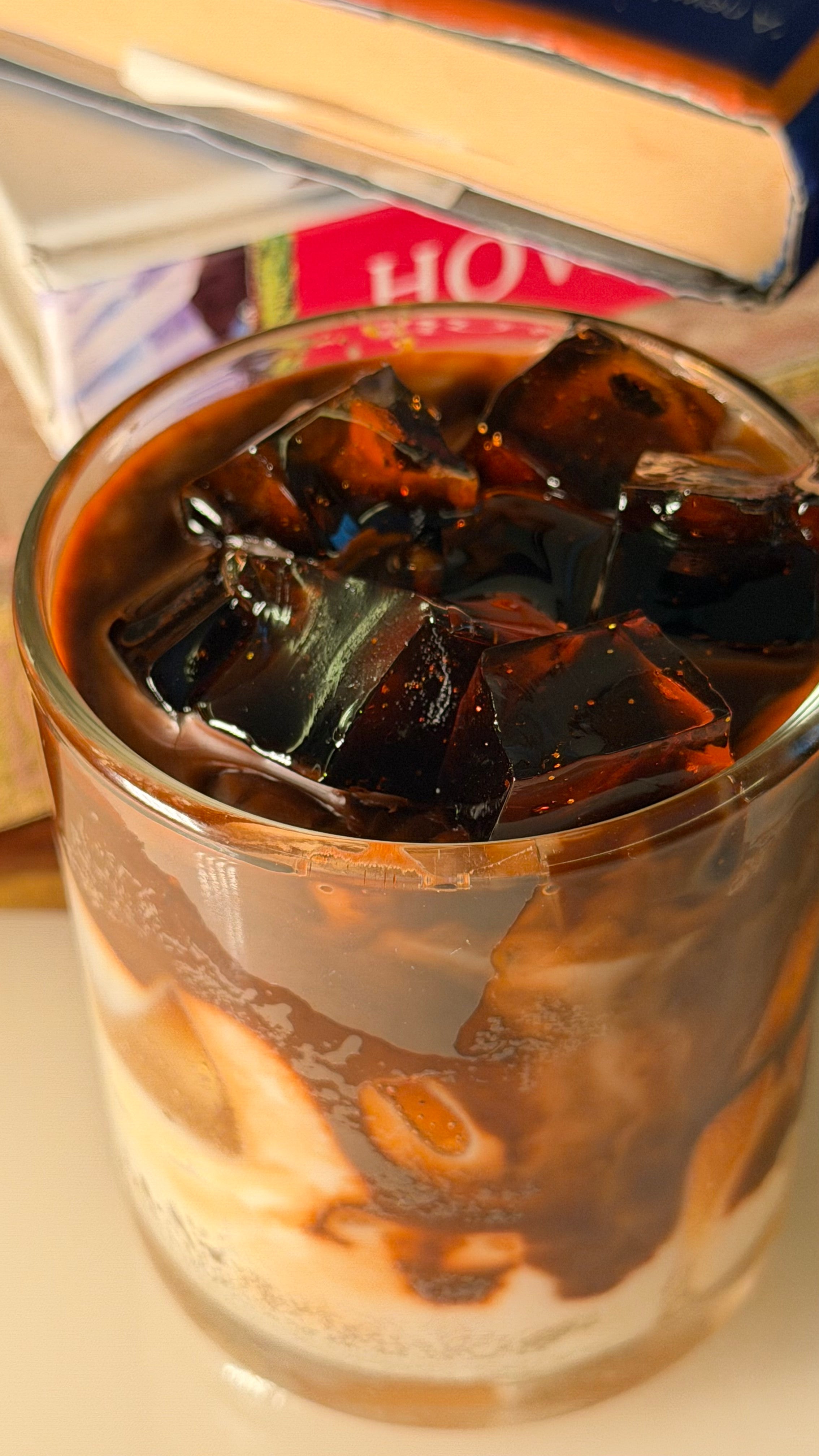 Close-up of realistic gel wax ice cubes on the cold coffee candle