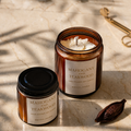 Two Mahogany and Teakwood candles on a marble surface