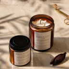 Two Mahogany and Teakwood candles on a marble surface